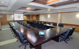 video conferencing table with chairs and dropdown screen