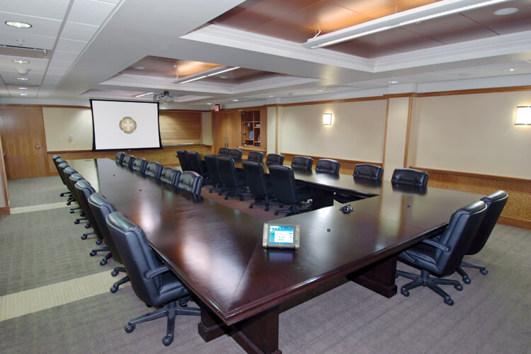 video conferencing table with chairs and dropdown screen