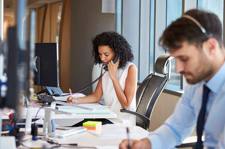 woman answering her business desktop phone