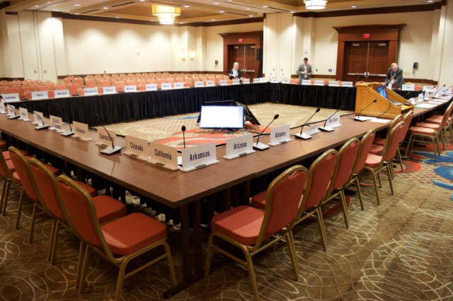 large conference table with displays in the center and microphones at each seat