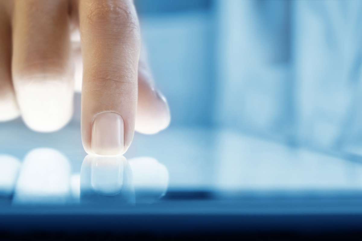 Woman hand touching screen digital tablet pc. Closeup shot. Small depth of field. Soft focus.