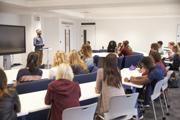 students in a college classroom answering questions