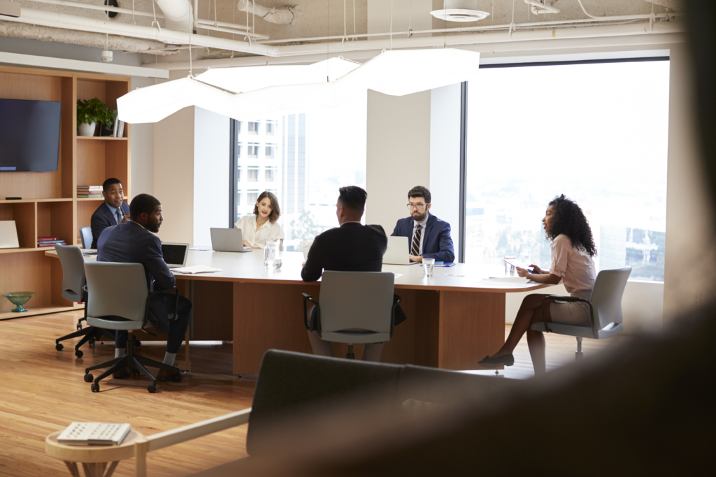 Group Of Business Professionals Meeting Around Table In Modern Office