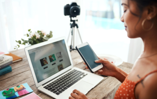Home workspace with laptop smartphone and DSLR camera on tripod