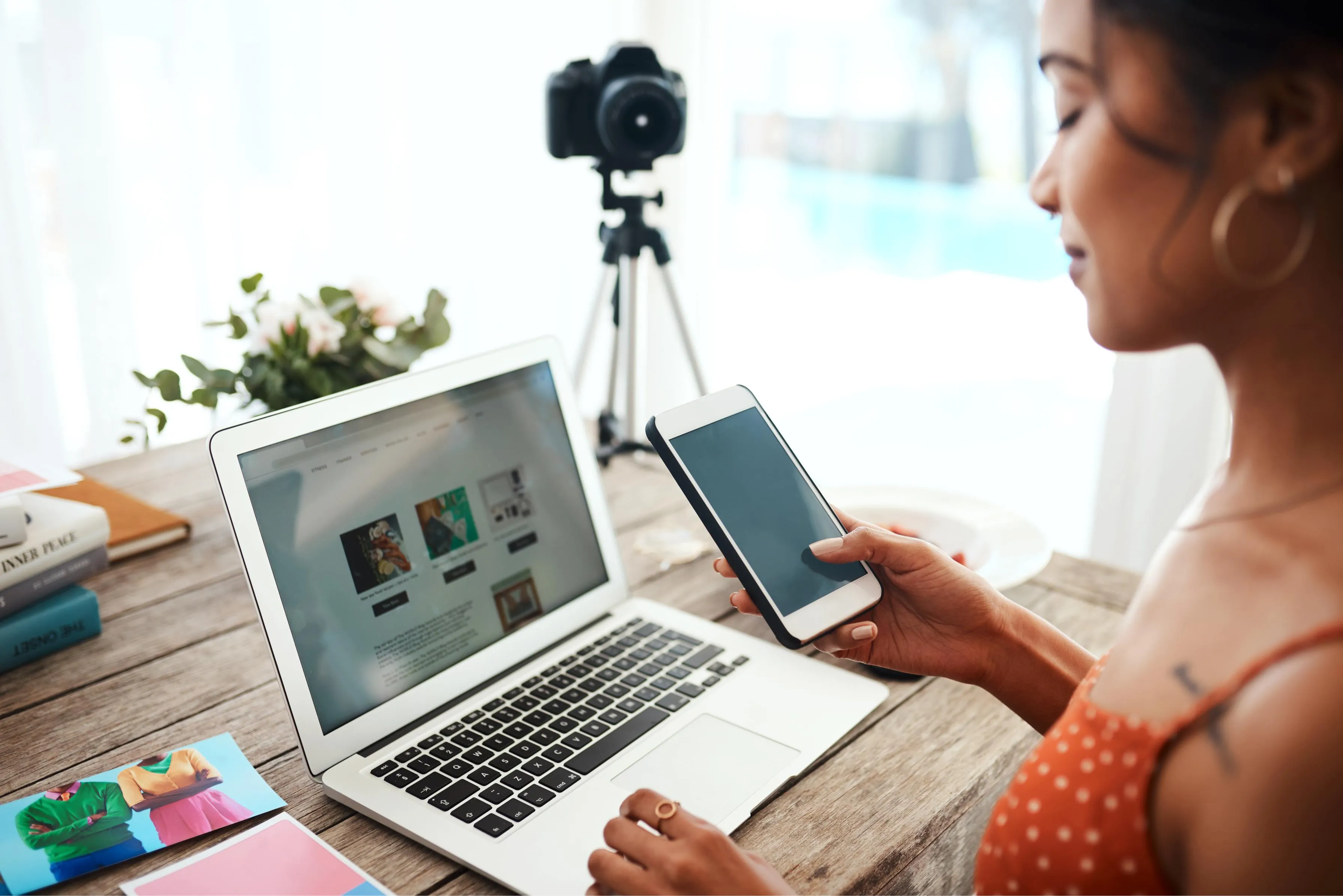 Home workspace with laptop smartphone and DSLR camera on tripod