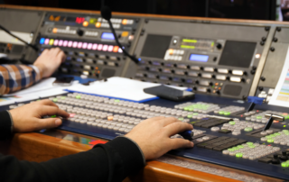 Person operating video switcher panel in control room