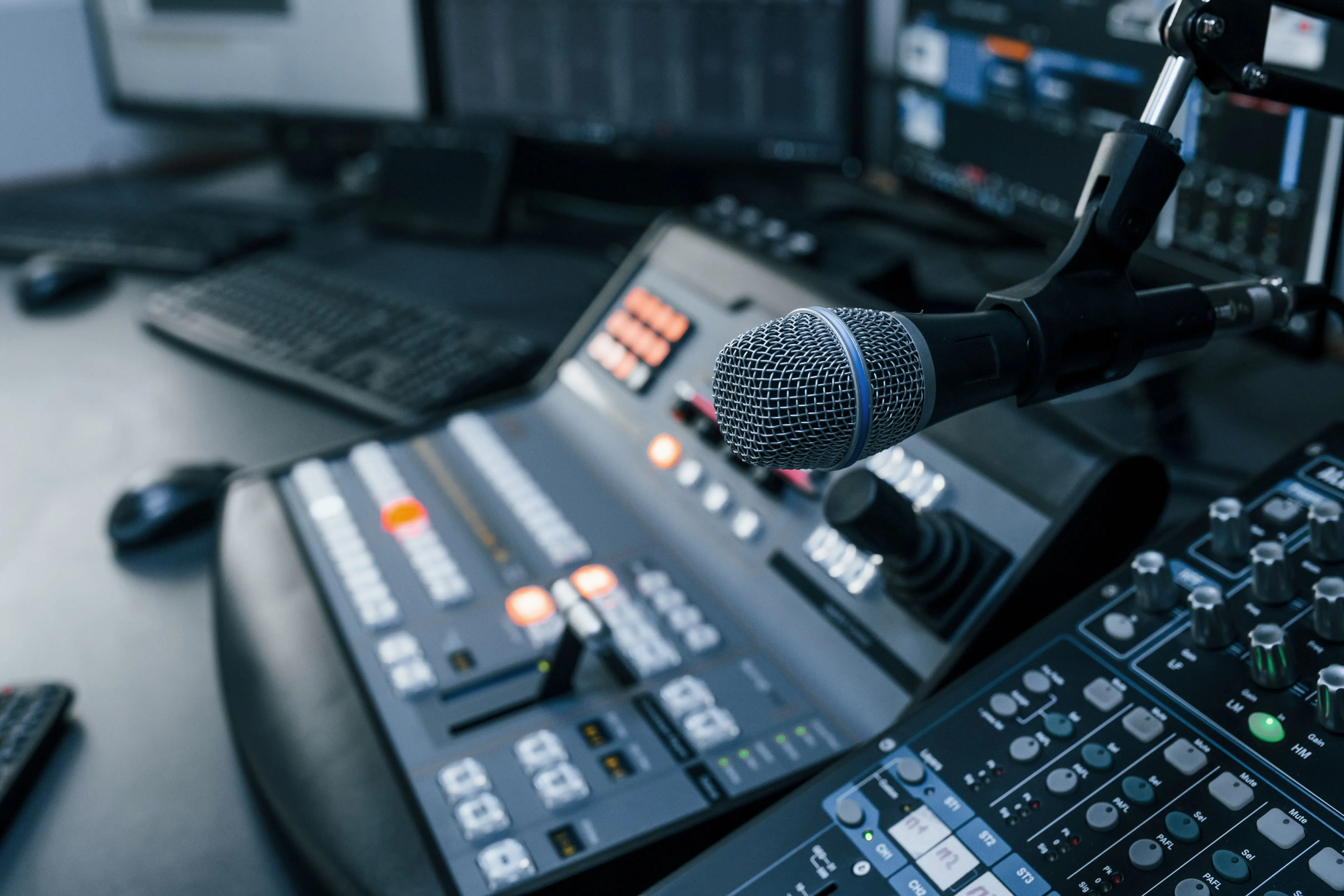 Microphone setup in radio studio with control panel and monitors