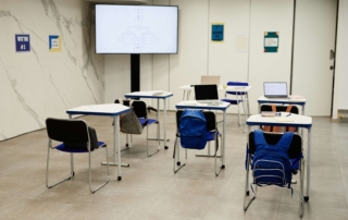 empty classroom desks with laptops
