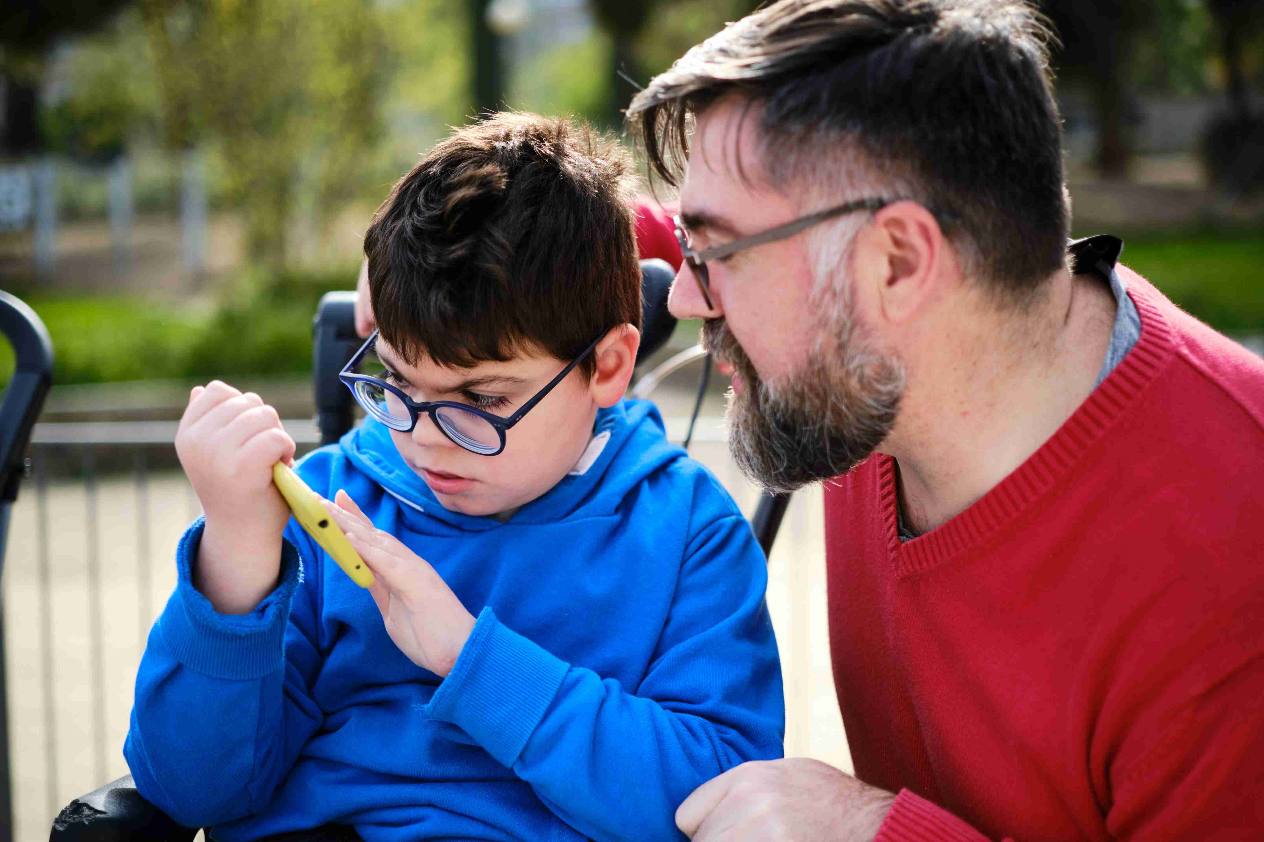 boy and man interacting over a smartphone