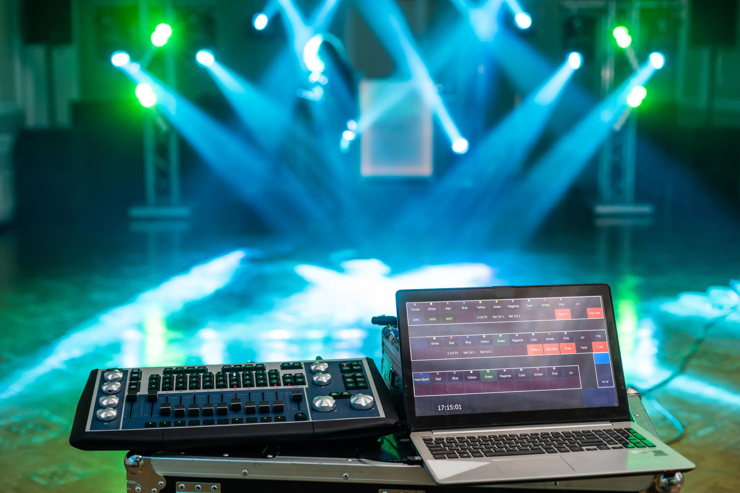 laptop and lighting console controlling colored stage spotlights