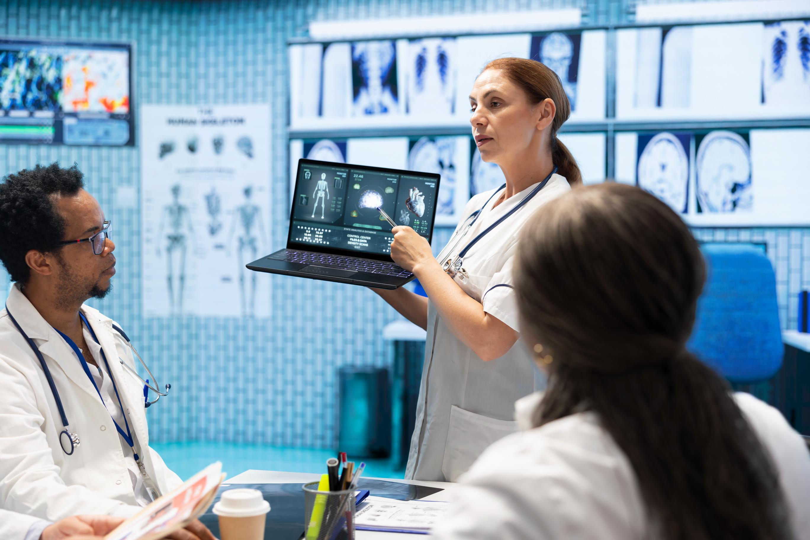 medical team reviewing patient data around laptop device laptop