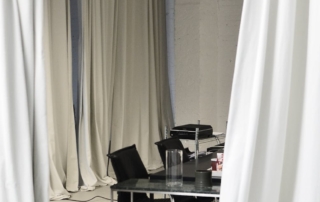 draped curtains framing a workspace with projector on a rolling cart