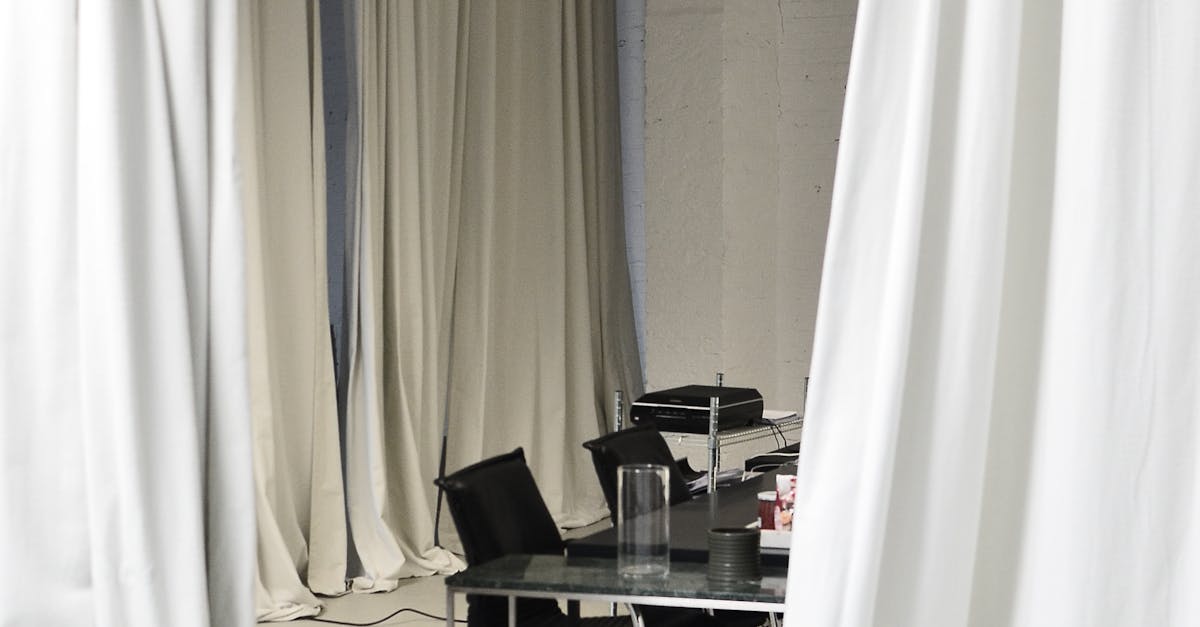 draped curtains framing a workspace with projector on a rolling cart