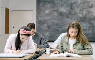 students writing with notebooks at desks