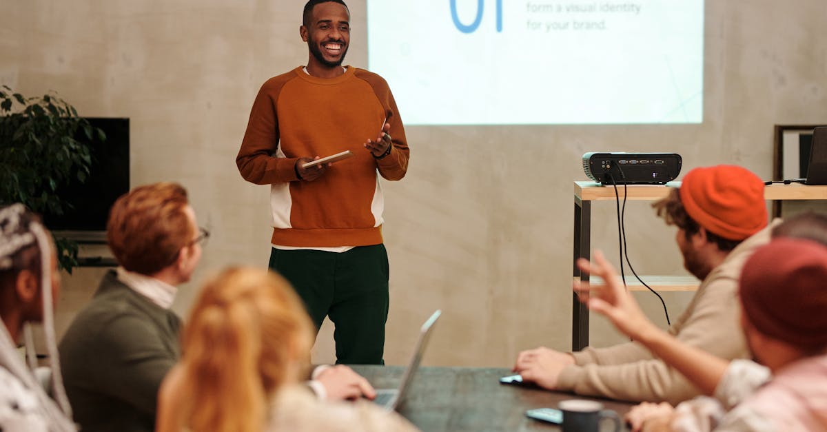 presenter standing before group with projector and screen visible