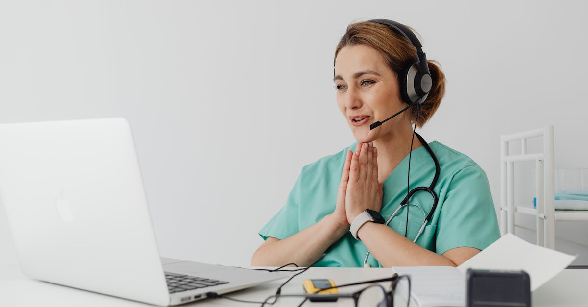 female doctor wearing headset on telehealth video call with laptop