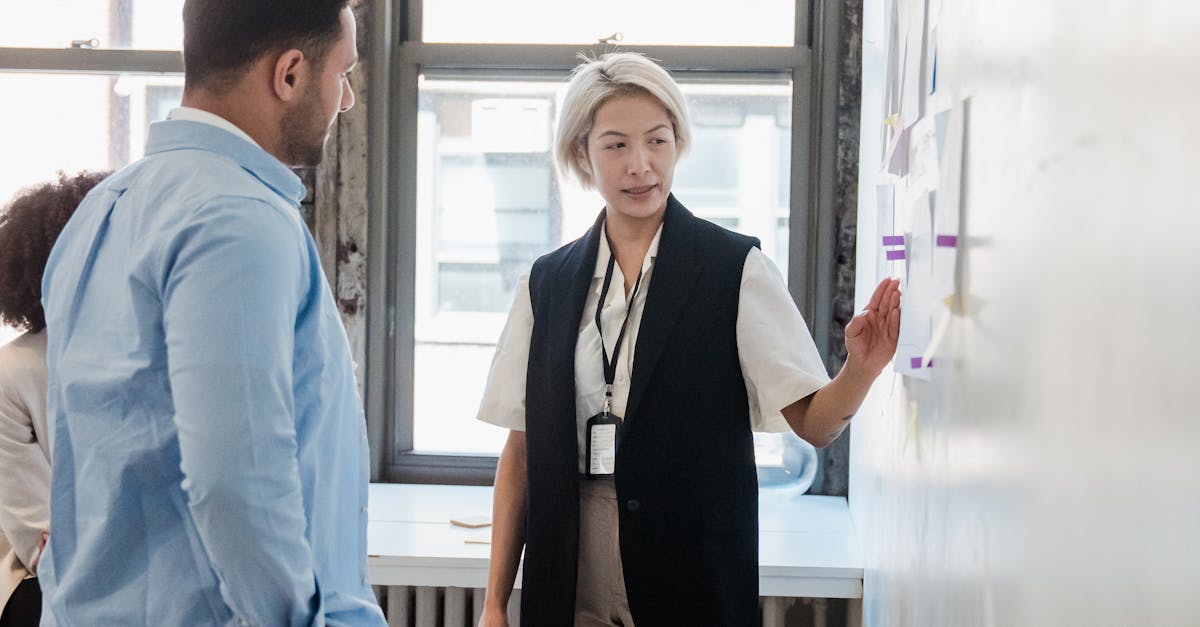 businesswoman pointing at sticky notes on whiteboard