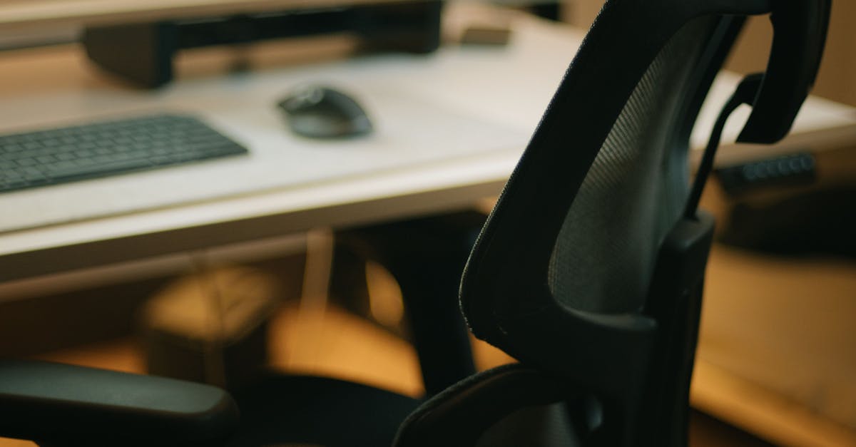 mesh office chair with keyboard monitor and mouse in background