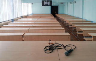 empty lecture hall with microphone on desk and ceiling screen