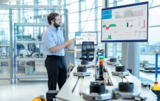 engineer analyzing data on large monitor in factory