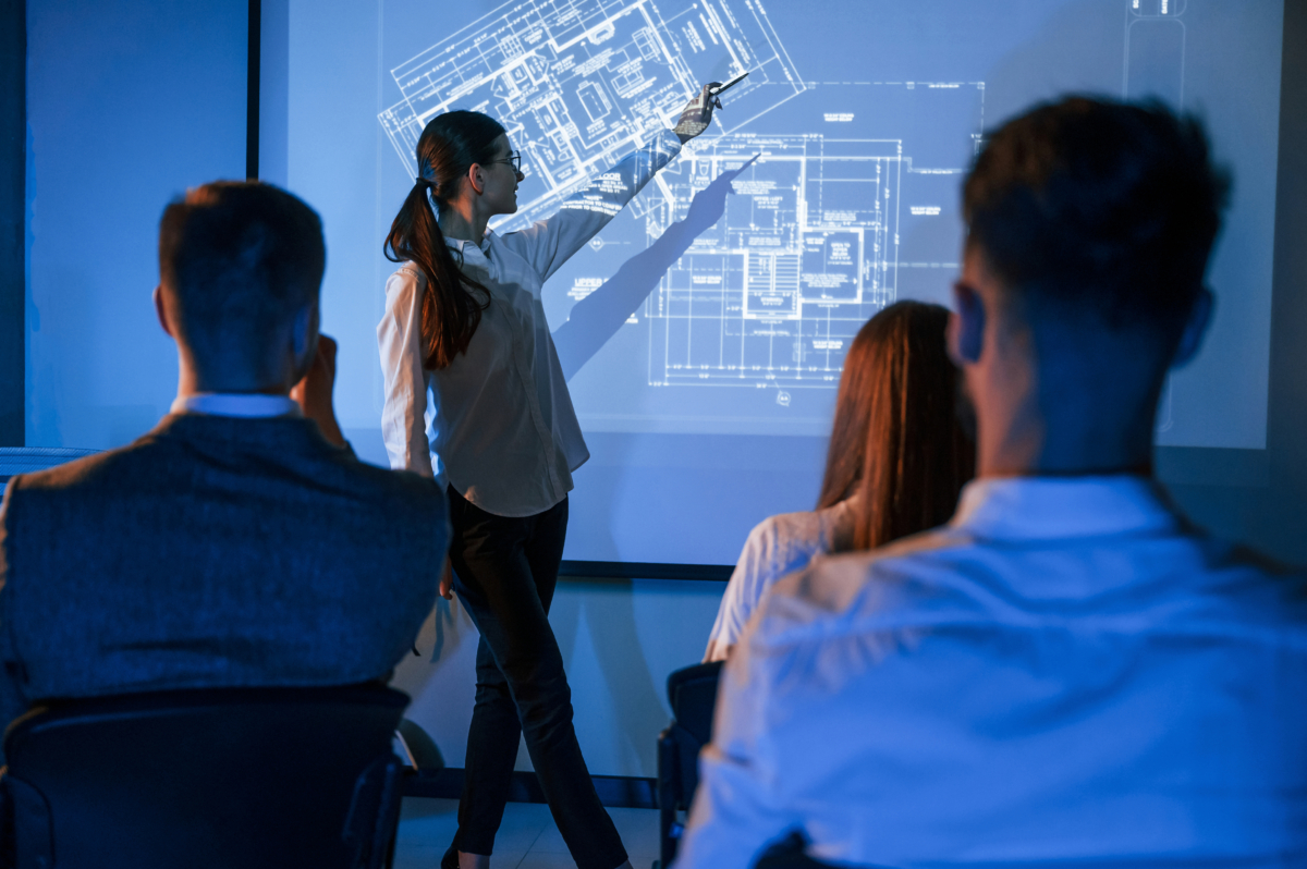 woman training a team on the layout of a building's av system