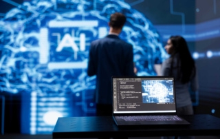 laptop displaying code on table with large screen in background