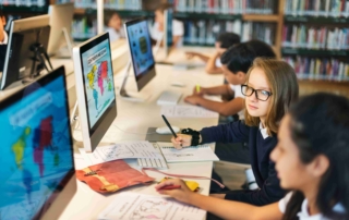 Students using desktop computers in library classroom