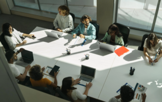 overhead view of meeting table with laptops tablet and papers