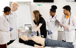 medical students training with patient simulator and monitor