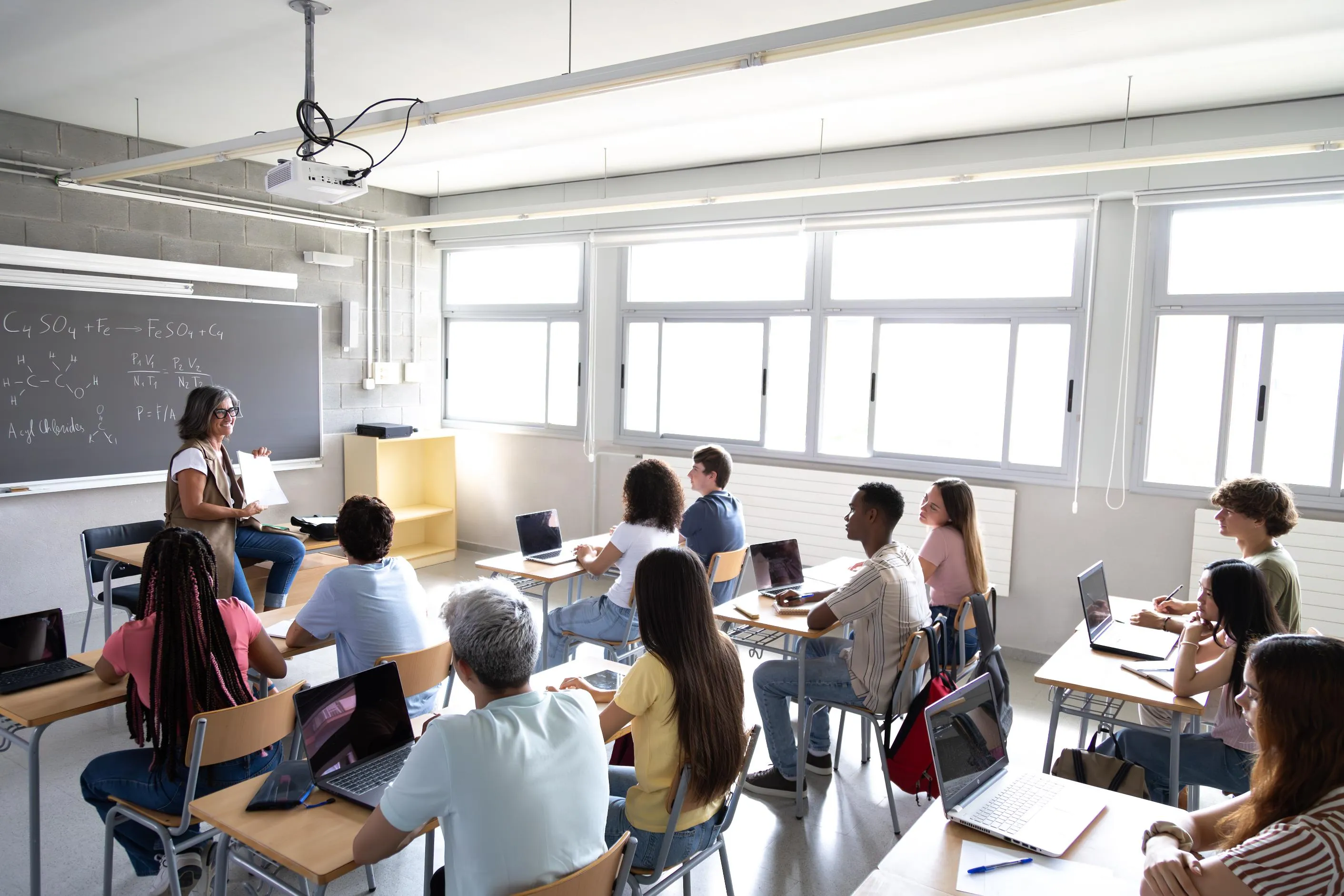 classroom of students with laptops and teacher
