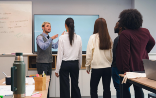 Group discussion in classroom in front of flat screen display