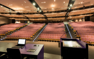 empty auditorium stage view from behind lectern with laptop monitor