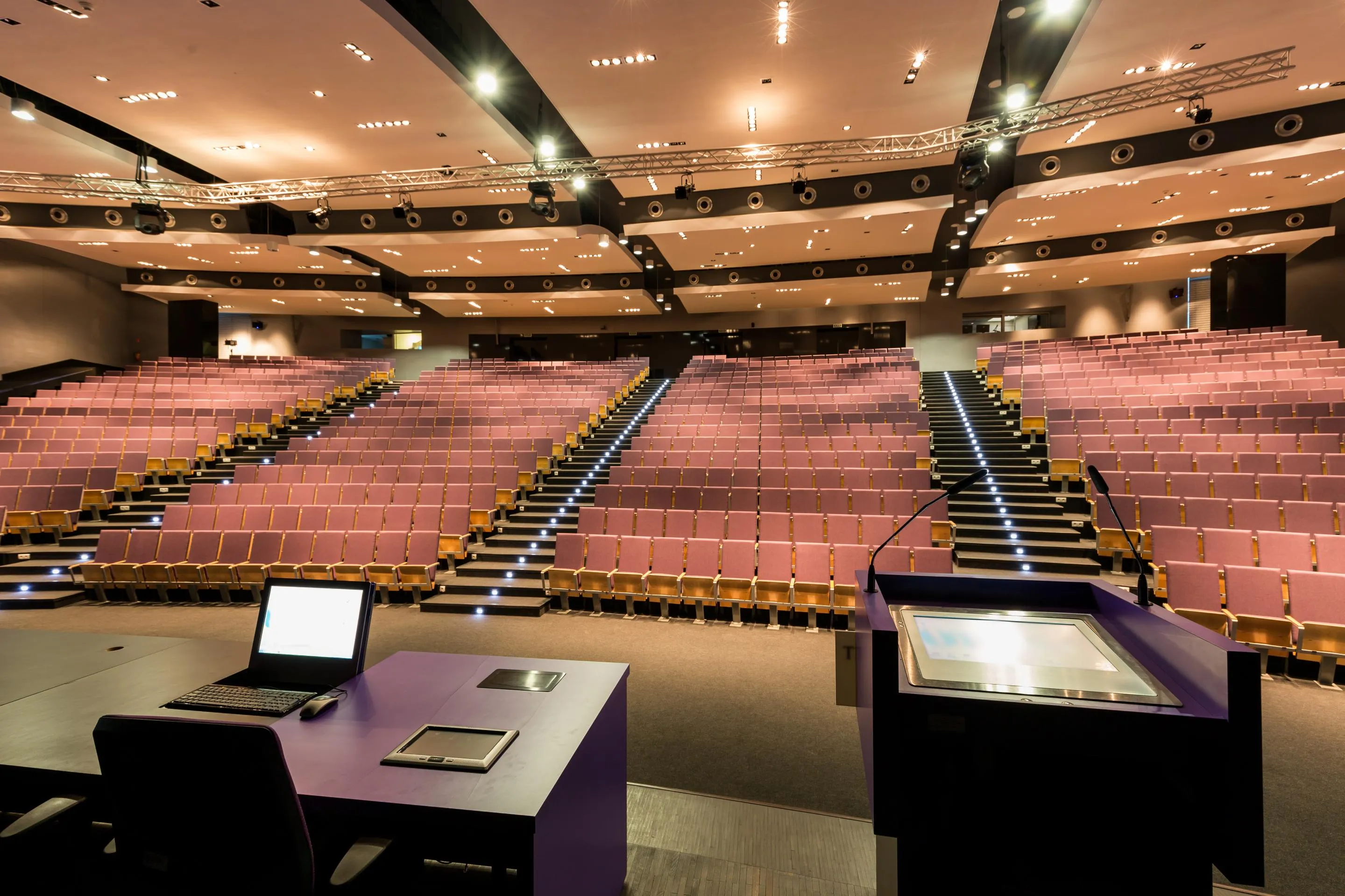empty auditorium stage view from behind lectern with laptop monitor