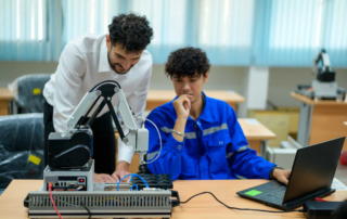 instructor and student with robotic arm and laptop