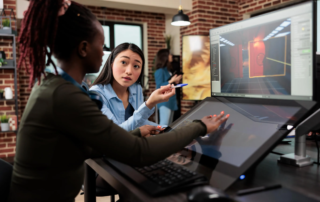 Woman explaining 3D design on large monitor and drawing tablet