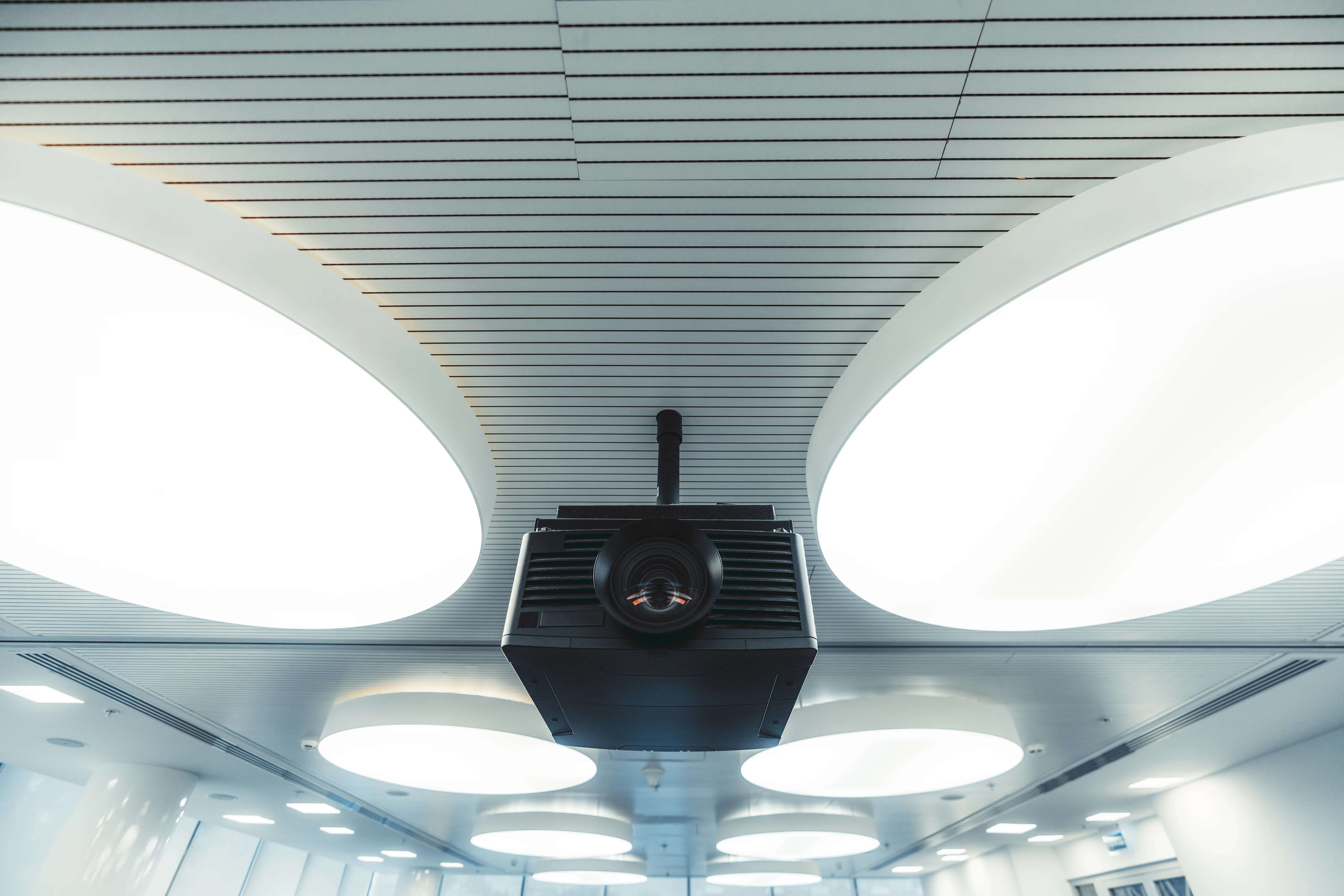 Modern ceiling with round lights and suspended projector unit