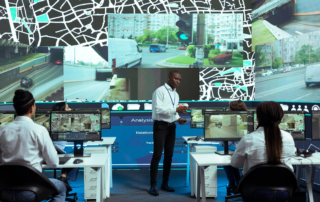 People analyzing traffic surveillance footage on multiple large monitors