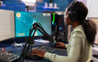 streamer at desk with dual monitors keyboard microphone and headphones