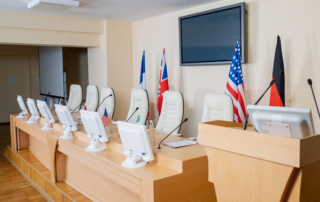 International conference room with monitors microphones and national flags