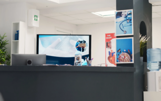 reception desk with a monitor and water cooler visible