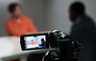 Camcorder recording two people in interrogation room