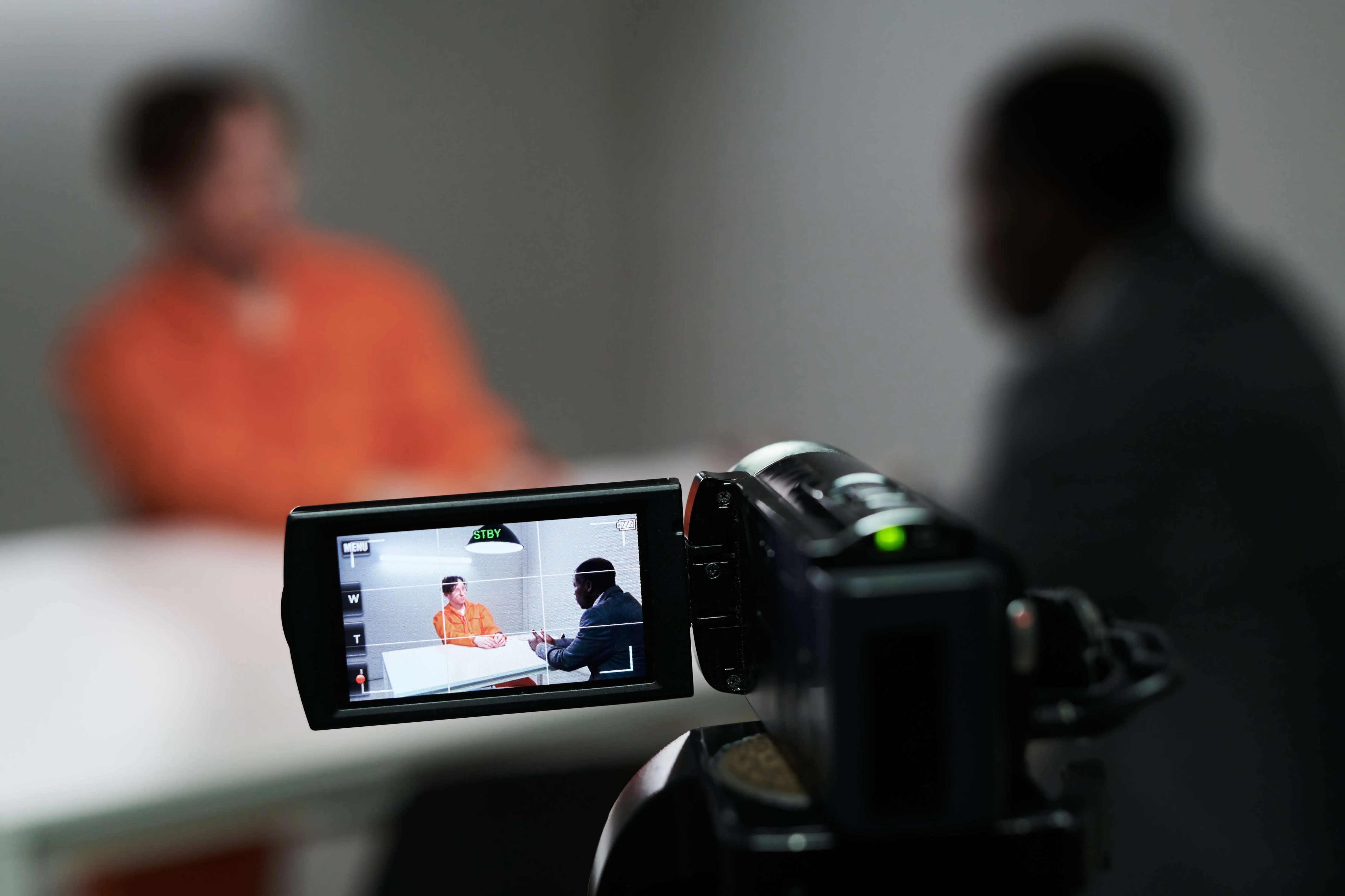 Camcorder recording two people in interrogation room
