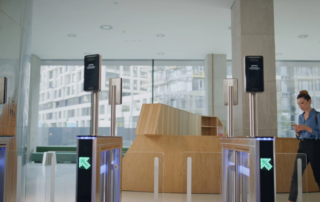 Woman walking through automated security gate using phone