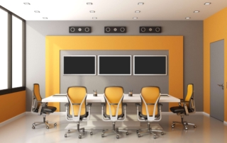 three blank monitors on a grey and orange wall