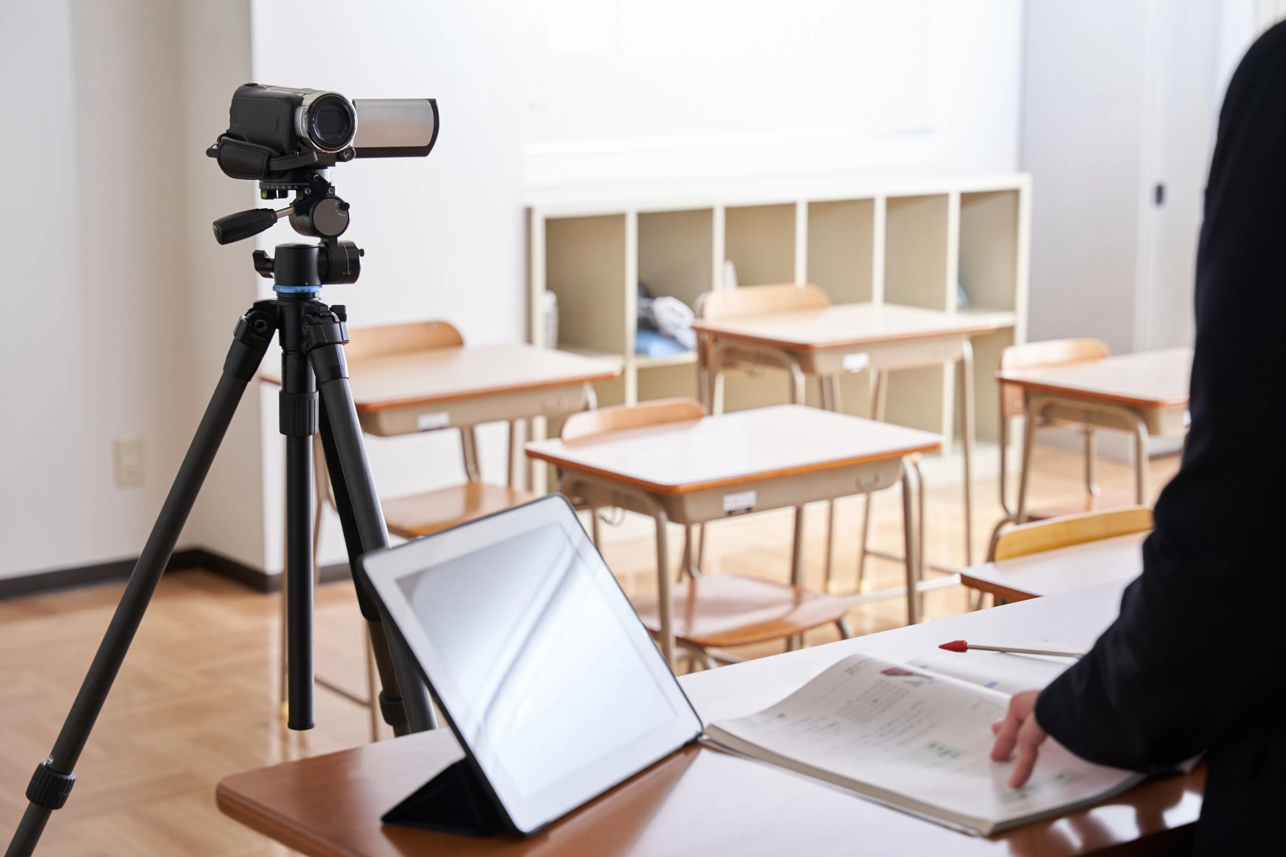 image-of-filming-an-online-class-in-a-classroom-2025-03-13-19-50-55-utc tripod‑mounted video camera beside a tablet