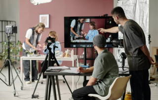 Video production team reviewing shoot on large monitor with cameras