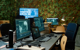 Intelligence office with multiple monitors and laptops displaying world maps