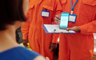 Person in orange jumpsuit showing phone with online banking screen