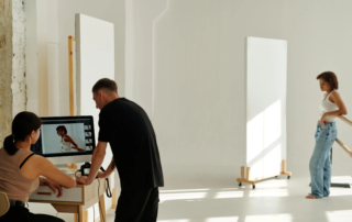 photographer and assistant reviewing shots on an iMac monitor