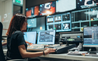 Control room operator managing broadcast on multiple screens